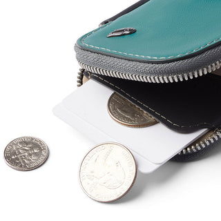 Bellroy Card Pocket in teal leather with visible stitching and zipper holding cards and coins