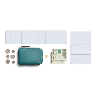 Bellroy Card Pocket in teal leather with coins, cash, and cards displayed on white background