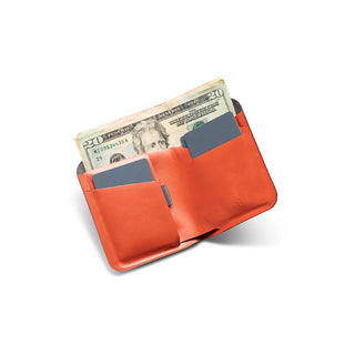 Bellroy Apex Note Sleeve wallet open displaying orange leather with cash and cards inside