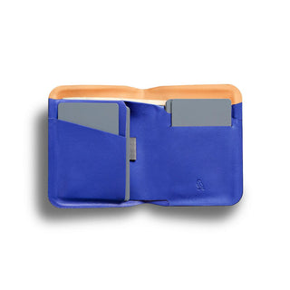 Bellroy Apex Note Sleeve open showing blue leather interior and card slots with an orange edge lining