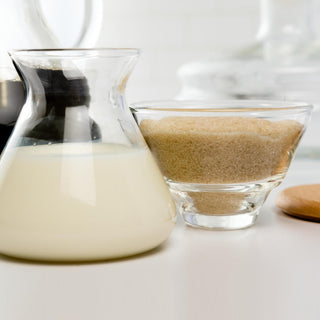 Chemex Cream and Sugar Set with borosilicate glass containers holding milk and brown sugar on white surface