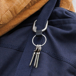 Orbitkey Clip Mini zinc alloy key organizer clipped to navy backpack strap with keys attached