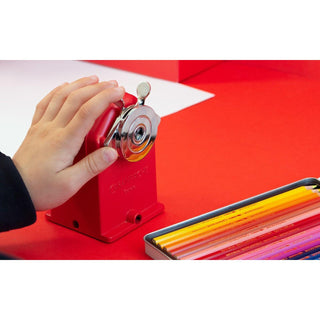 Caran d'Ache Pencil Sharpener Standard Edition in red metal with crank handle sharpening colored pencils
