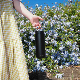 FELLOW Fellow Carter Carry Tumbler (32oz/946ml) black stainless steel with carry handle held outdoors