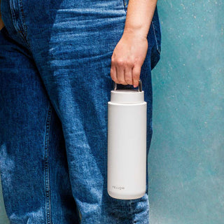FELLOW Fellow Carter Carry Tumbler (32oz/946ml) in matte white held by person wearing blue jeans