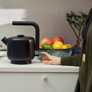 Fellow Clyde Electric Kettle (120V) (1500ml/50oz) matte black stainless steel design on kitchen counter