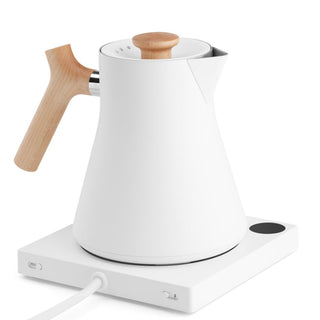 Fellow Corvo EKG Electric Kettle (120V) with white stainless steel body and wooden handle on white base