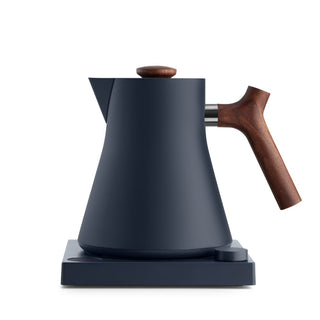 Fellow Corvo EKG Electric Kettle (120V) with matte black body and ergonomic wooden handle on base