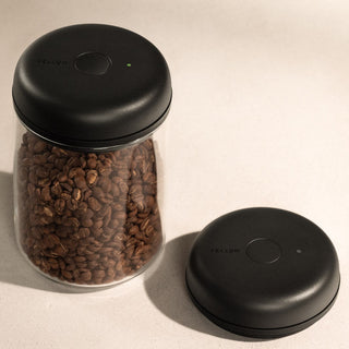 Fellow Electric Atmos Vacuum Canister - Clear Glass jar filled with coffee beans and black lid removed next to it
