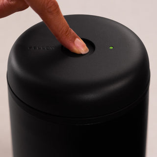 Fellow Electric Atmos Vacuum Canister - Matte Black with smooth lid pressed by finger and green indicator light