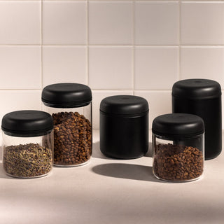 Fellow Electric Atmos Vacuum Canister - Clear Glass jars with black lids holding coffee beans and tea leaves
