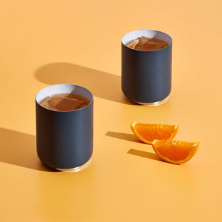 FELLOW Rocky Lowball Tumbler (10oz/296ml) in matte black stainless steel with iced drinks and orange slices