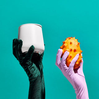 FELLOW Ruby Wine Tumbler (12oz/355ml) held in satin green glove against teal background