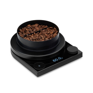 Fellow Tally Pro Precision Scale (Studio Edition) in black with coffee beans and digital display reading 60.0g