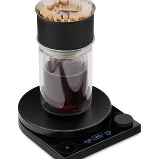 Fellow Tally Pro Precision Scale (Studio Edition) in black with digital display and glass coffee dripper on top