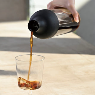 HARIO Filter In Coffee Bottle 650ml pouring cold brew coffee from clear glass bottle with black silicone lid