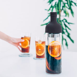 HARIO Filter In Coffee Bottle 650ml with black silicone lid and citrus-infused cold brew coffee inside