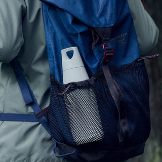 KINTO TRAIL Tumbler 580ml in white stainless steel held in a black mesh backpack side pocket