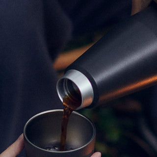 KINTO TRAIL Tumbler 1080ml black stainless steel tumbler pouring hot coffee into matching cup