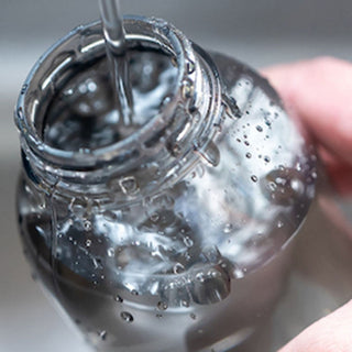 KINTO WATER Bottle 300ml being filled with water, showing clear copolyester material and open top design