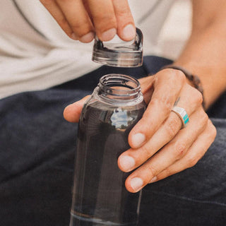 KINTO WATER Bottle 500ml being opened, clear copolyester bottle held by hand with silver ring