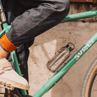 KINTO WATER Bottle 500ml transparent tumbler attached to green Surly bicycle frame in outdoor setting