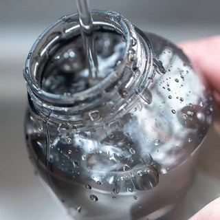 KINTO WATER Bottle 950ml being filled with water showing clear copolyester material and top opening design