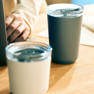 KINTO To Go Tumbler (with plug) 360ml in matte dark gray with clear lid on wooden table near laptop