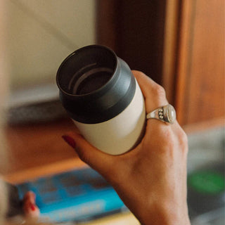 KINTO Travel Tumbler 350ml held in hand featuring stainless steel body and black lid design