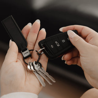 Orbitkey Loop Keychain in black Nappa leather holding keys and a car remote in hand