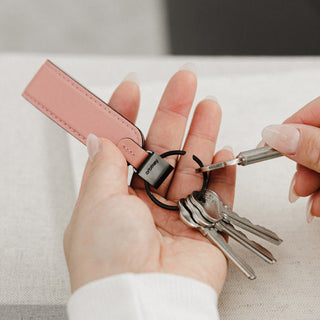Orbitkey Loop Keychain with pink leather strap and black metal ring holding multiple keys in hand