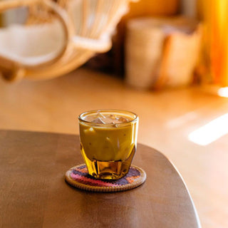 notNeutral VERO Cappuccino Glass 6oz filled with iced coffee on a colorful coaster on wooden table