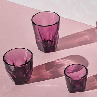 notNeutral VERO Cappuccino Glass 6oz set in translucent purple glassware with geometric facets on pink surface