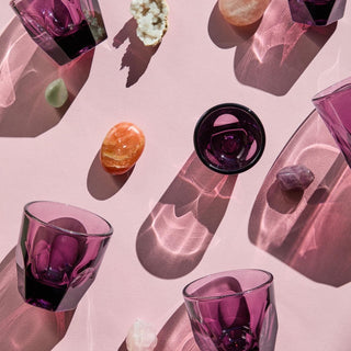 notNeutral VERO Cappuccino Glass 6oz in purple tinted glass with light reflections on pink background