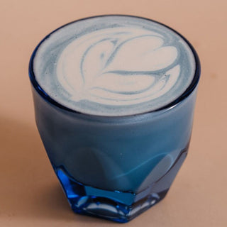notNeutral VERO Cappuccino Glass 6oz filled with coffee showcasing creamy latte art and blue tinted glassware