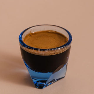 notNeutral VERO Espresso Glass 3oz filled with espresso showcasing thick blue glass base and rim