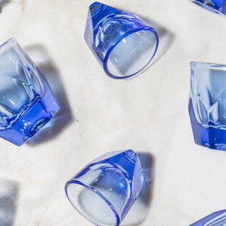notNeutral VERO Espresso Glass 3oz in blue tinted glass with faceted design on marble surface