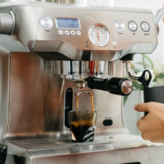 notNeutral VERO Espresso Glass 3oz catching fresh espresso under stainless steel coffee machine spout