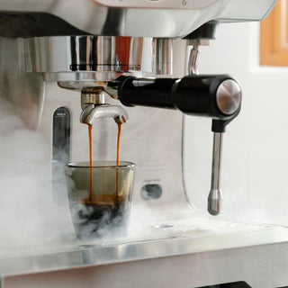 notNeutral VERO Espresso Glass 3oz catching rich espresso shot from stainless machine with steam rising