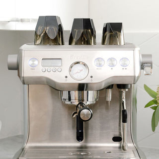 notNeutral VERO Cappuccino Glass 6oz stacked upside down on espresso machine showcasing glass clarity and design