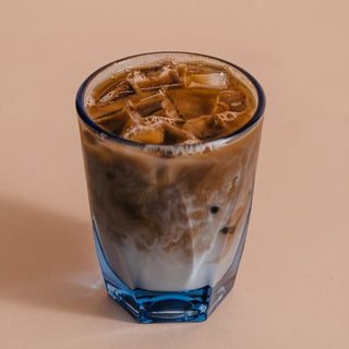 notNeutral VERO Latte Glass 12oz filled with iced latte showing clear glass texture and blue base detail