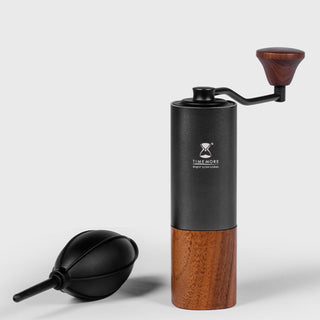 Timemore Air Blower next to a black silicone bulb and wooden-handled coffee grinder on white background