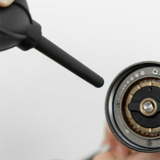 Timemore Air Blower with black silicone nozzle cleaning residue from a coffee grinder components close-up