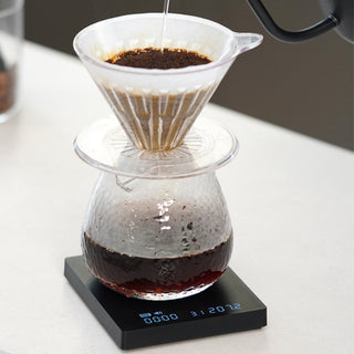 Timemore Black Mirror Mini Coffee Scale displaying brewing time beneath glass coffee dripper with carafe