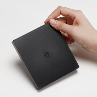 Timemore Black Mirror Mini Coffee Scale held by hand showing sleek matte black surface and touch buttons