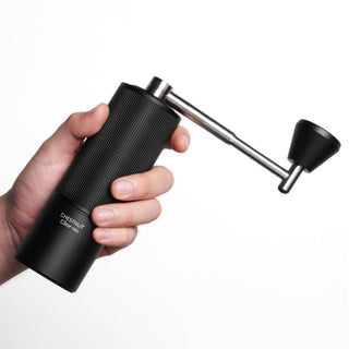 Hand holding Timemore Chestnut C3 ESP PRO Grinder with textured black aluminum body and stainless steel handle