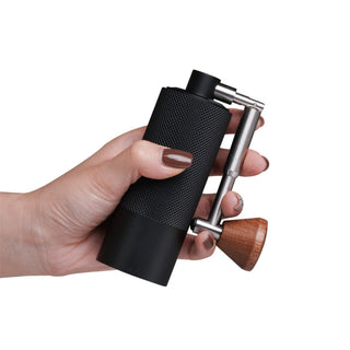 Timemore Chestnut Nano 3 Grinder held in hand showing textured black aluminum body and wooden handle knob