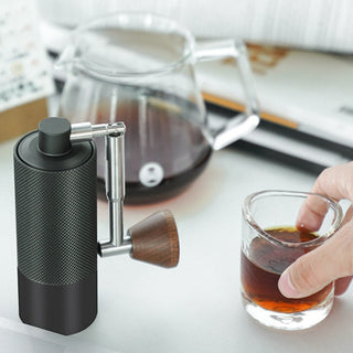 Timemore Chestnut Nano 3 Grinder with walnut handle next to hand holding espresso shot cup
