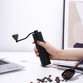 Timemore Chestnut Slim 3 Grinder held, featuring black aluminum body and wooden handle knob