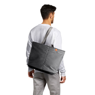 Man carrying Bellroy Lite Cooler Tote 16L in dark textured recycled nylon fabric on shoulder